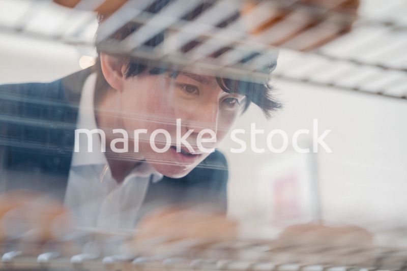 パティスリーでスイーツを買う若い男性