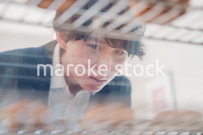 パティスリーでスイーツを買う若い男性