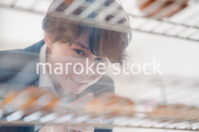 パティスリーでスイーツを買う若い男性