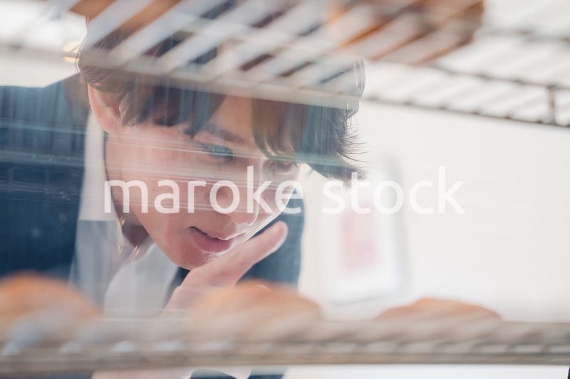 パティスリーでスイーツを買う若い男性