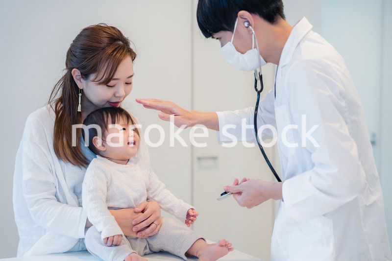 笑顔でドクターの診察を受ける赤ちゃん