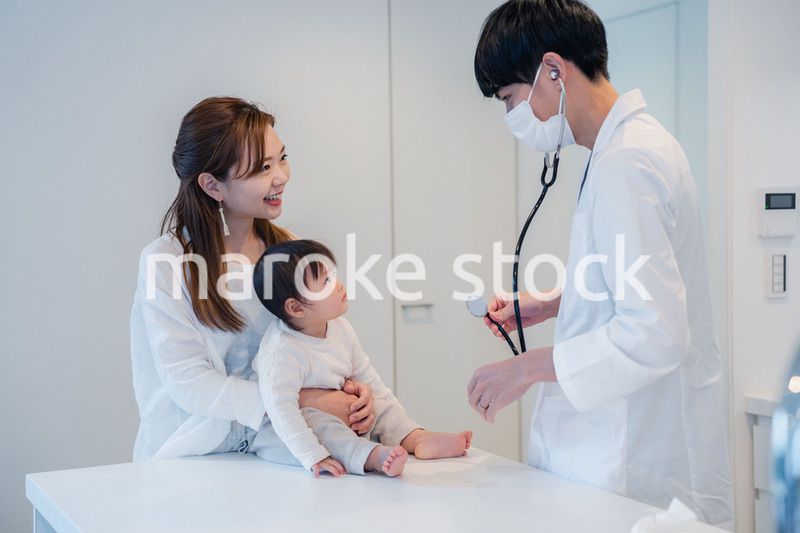 笑顔でドクターの診察を受ける赤ちゃん
