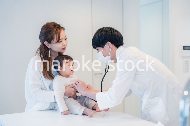 笑顔でドクターの診察を受ける赤ちゃん
