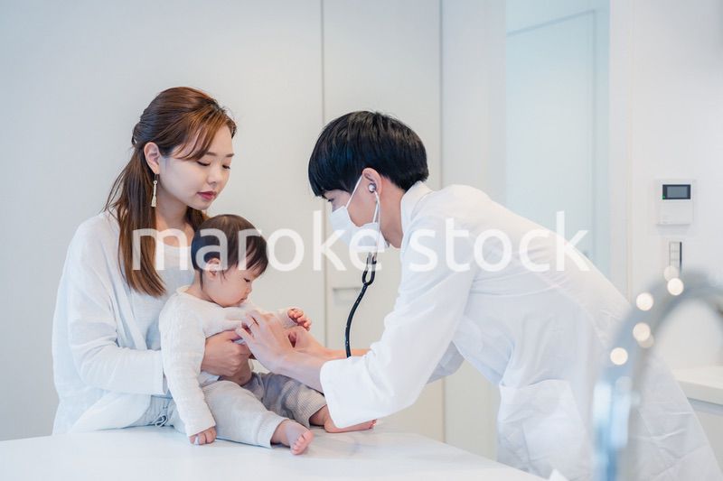 笑顔でドクターの診察を受ける赤ちゃん