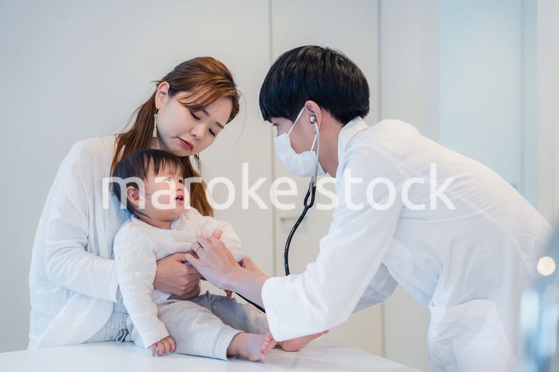 笑顔でドクターの診察を受ける赤ちゃん