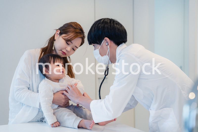 笑顔でドクターの診察を受ける赤ちゃん