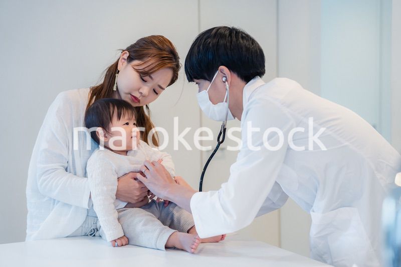 笑顔でドクターの診察を受ける赤ちゃん