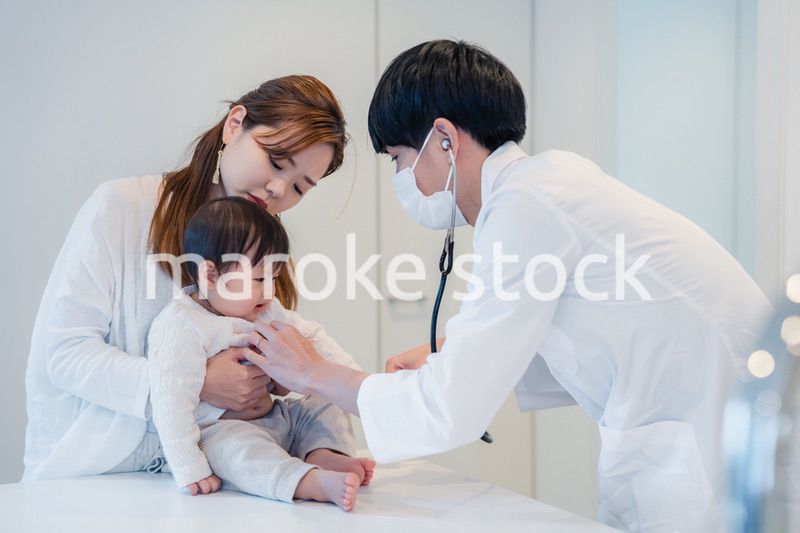 笑顔でドクターの診察を受ける赤ちゃん