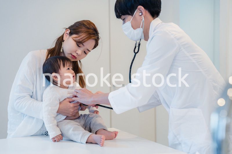 笑顔でドクターの診察を受ける赤ちゃん
