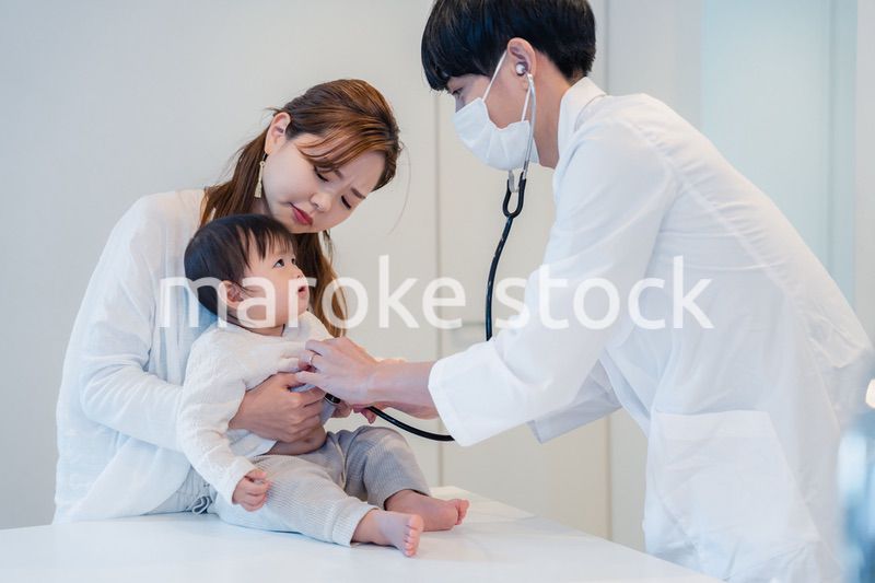 笑顔でドクターの診察を受ける赤ちゃん