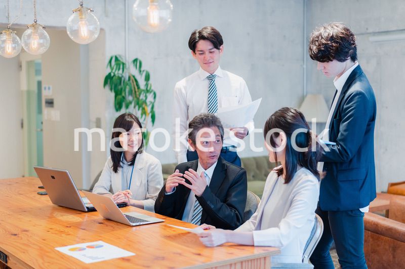 明るいオフィスに勤務をするビジネスパーソン