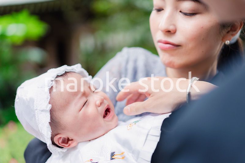 外で赤ちゃんを抱っこするお母さん
