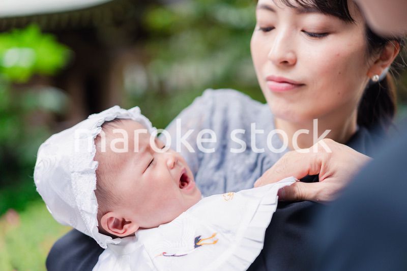 外で赤ちゃんを抱っこするお母さん