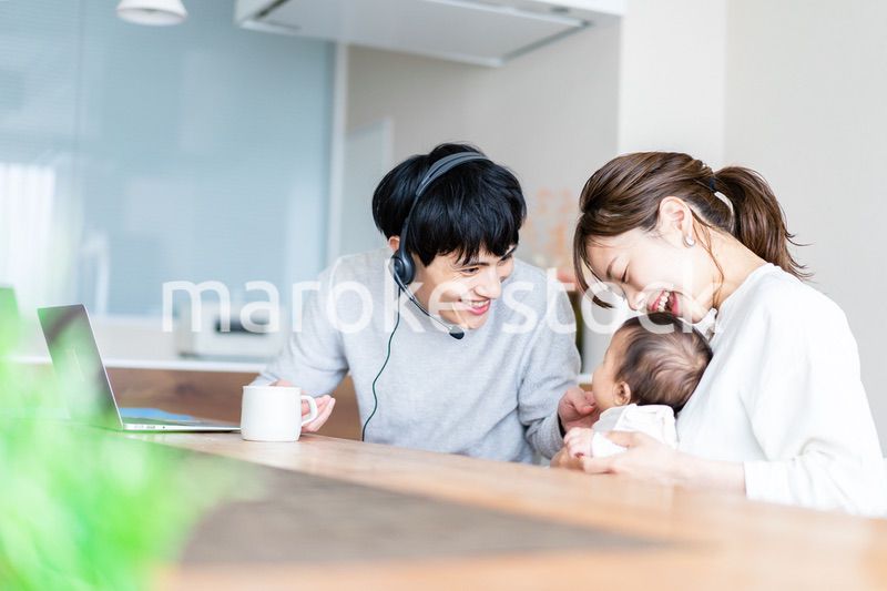 在宅勤務をするお父さんと子育てをするお母さん