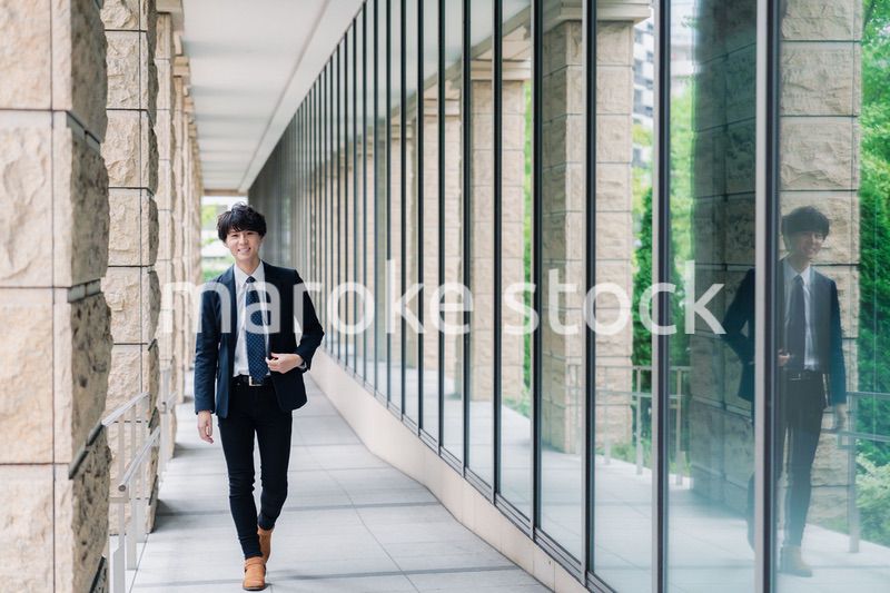 オフィスをさわやかに歩くビジネスマン