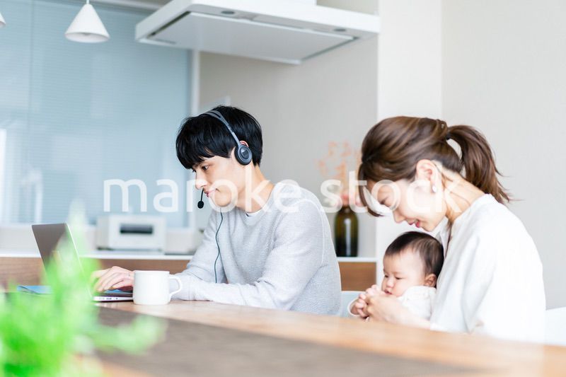 在宅勤務をするお父さんと子育てをするお母さん