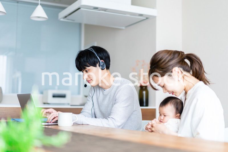 在宅勤務をするお父さんと子育てをするお母さん