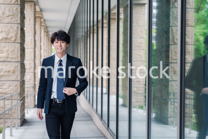 オフィスをさわやかに歩くビジネスマン