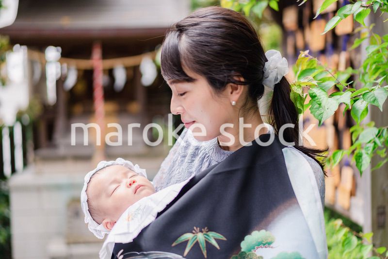 外で赤ちゃんを抱っこするお母さん