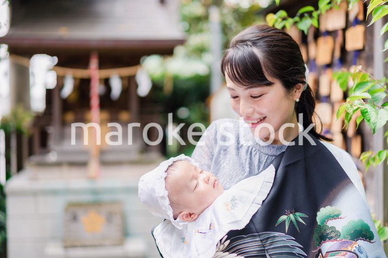 外で赤ちゃんを抱っこするお母さん