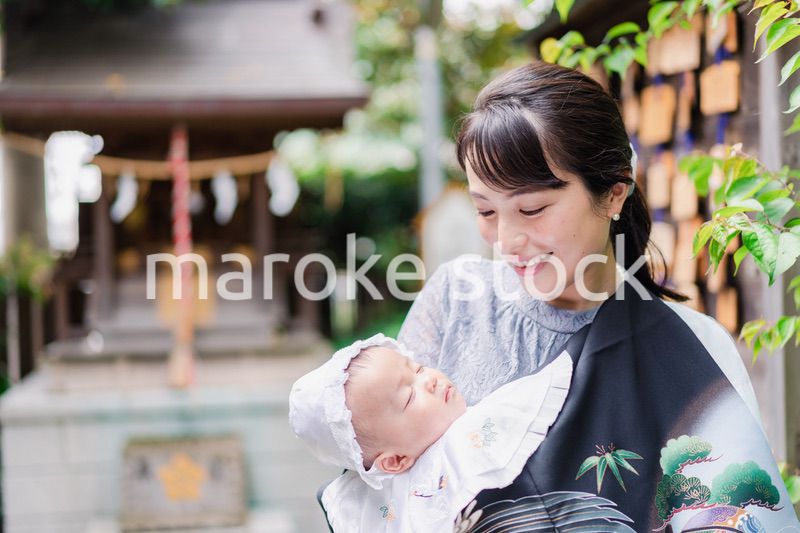 外で赤ちゃんを抱っこするお母さん