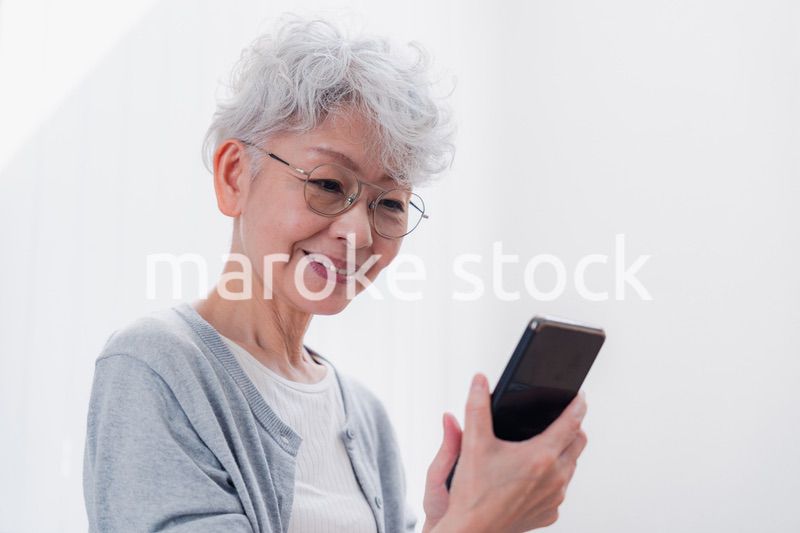 笑顔でスマホを操作するシニアの女性