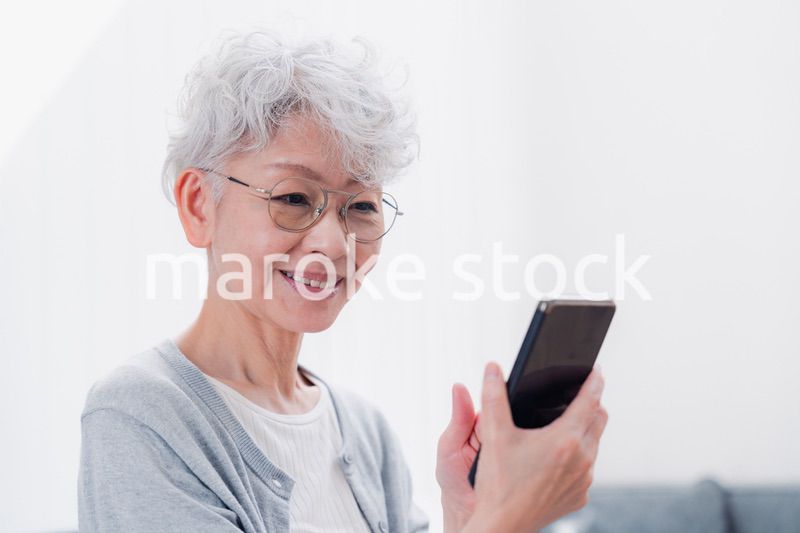 笑顔でスマホを操作するシニアの女性