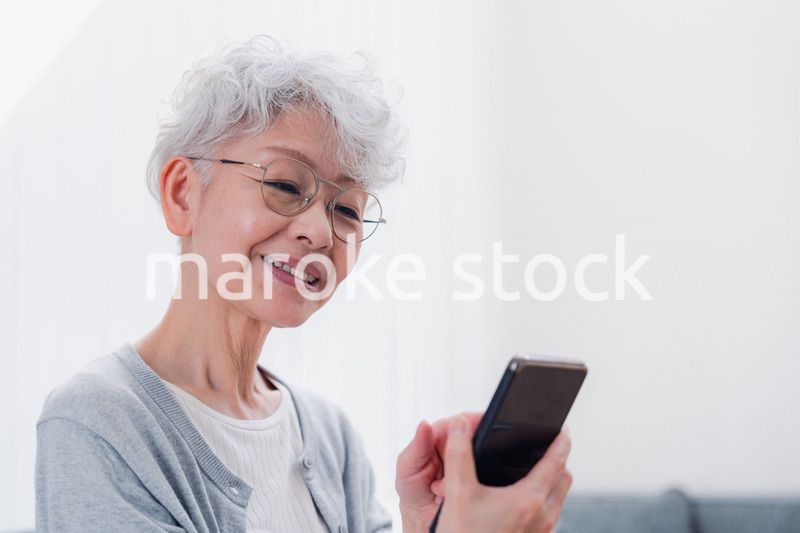 笑顔でスマホを操作するシニアの女性
