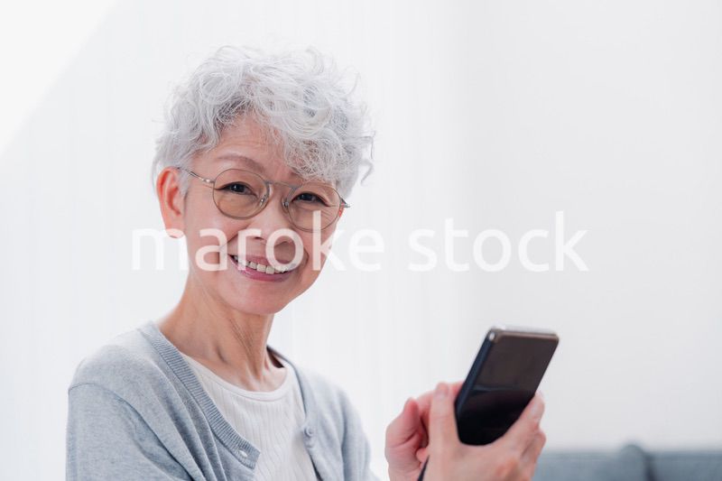 笑顔でスマホを操作するシニアの女性