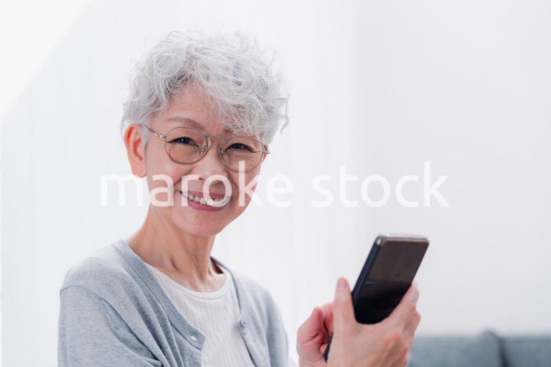 笑顔でスマホを操作するシニアの女性