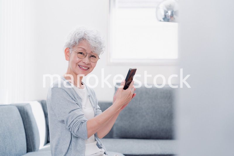 笑顔でスマホを操作するシニアの女性