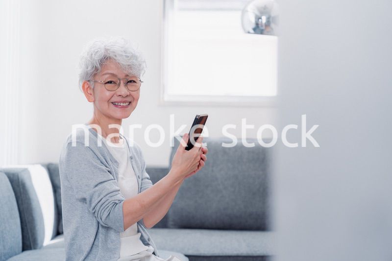 笑顔でスマホを操作するシニアの女性