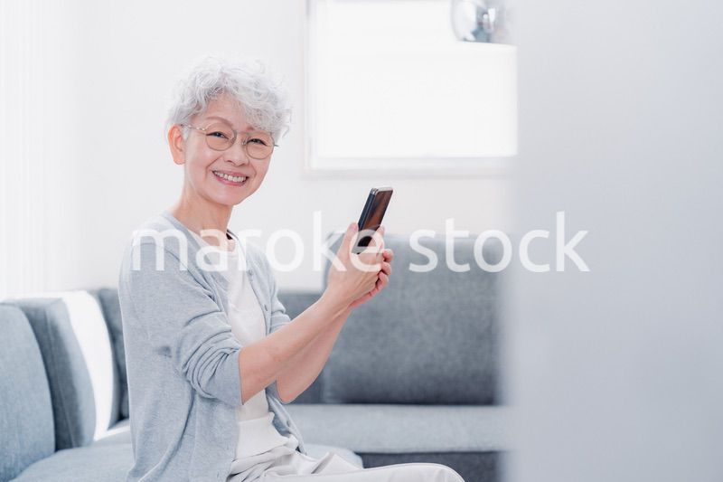 笑顔でスマホを操作するシニアの女性