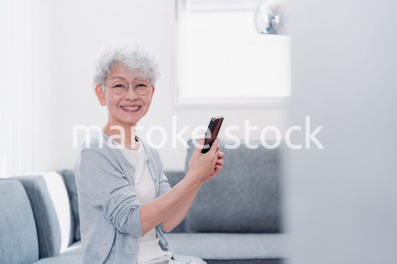 笑顔でスマホを操作するシニアの女性