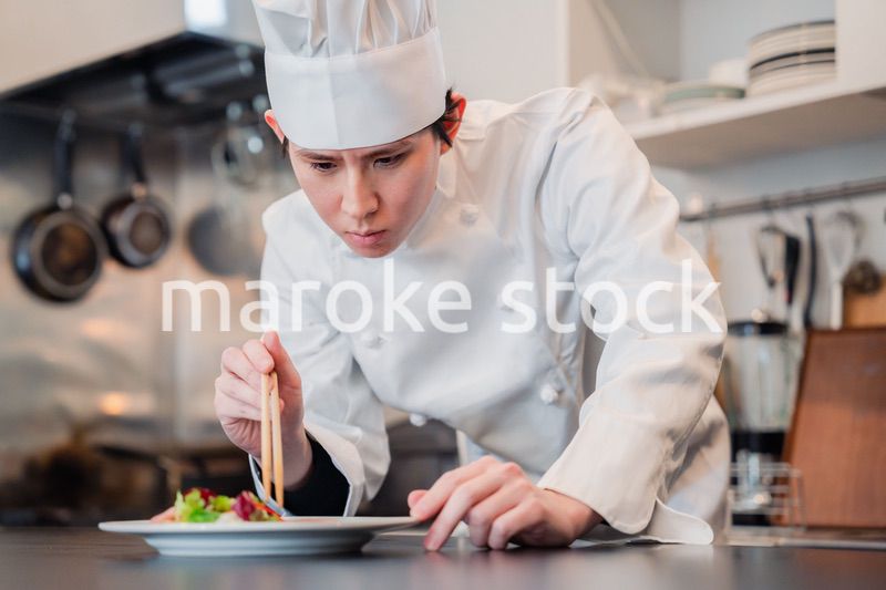 料理の盛り付けをする男性シェフ