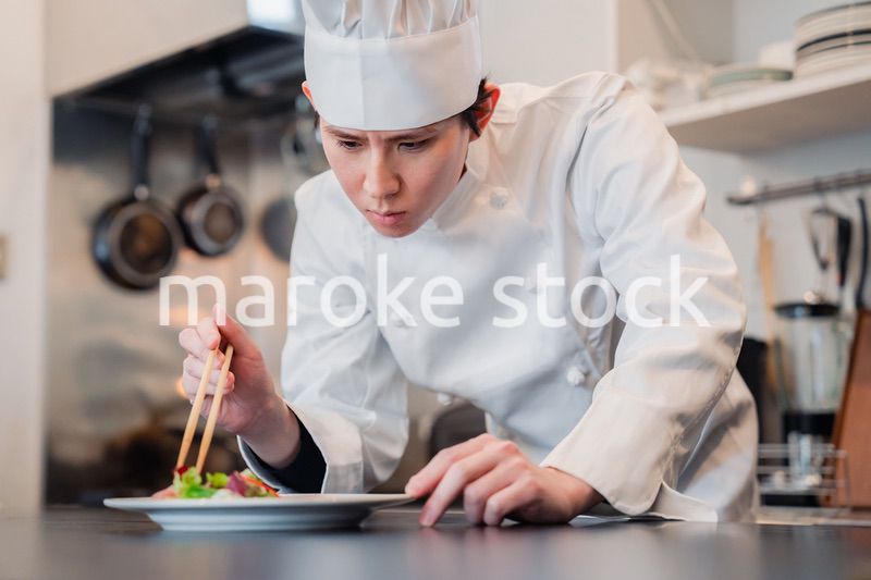 料理の盛り付けをする男性シェフ