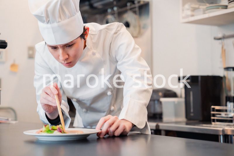 料理の盛り付けをする男性シェフ