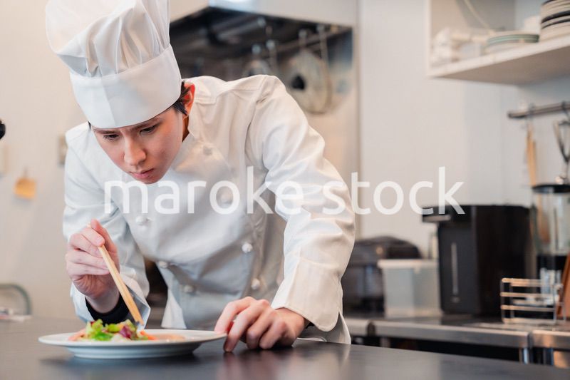 料理の盛り付けをする男性シェフ