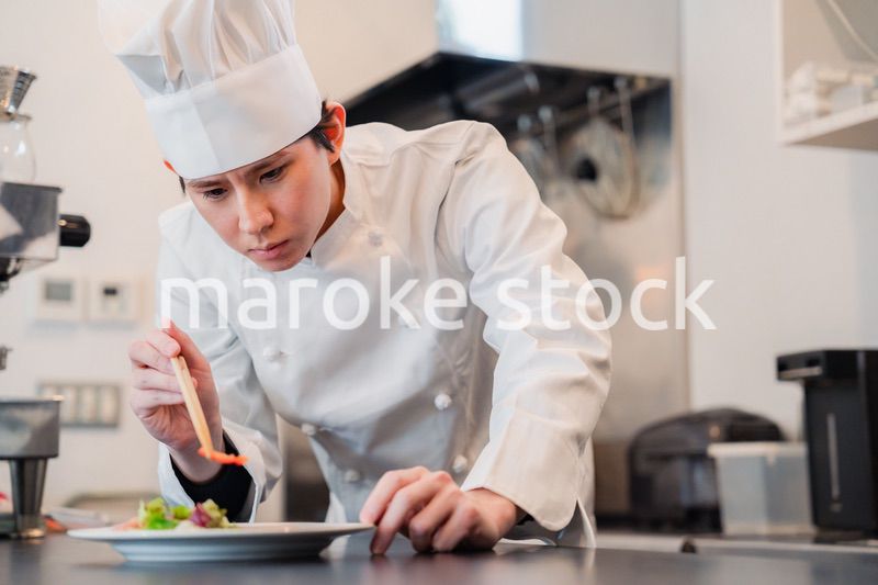 料理の盛り付けをする男性シェフ