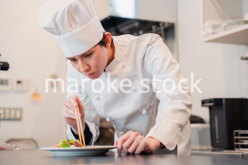 料理の盛り付けをする男性シェフ