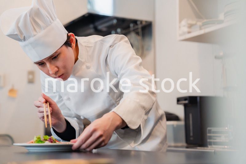 料理の盛り付けをする男性シェフ