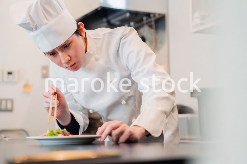 料理の盛り付けをする男性シェフ