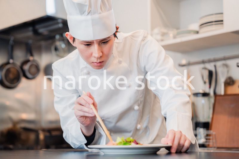 料理の盛り付けをする男性シェフ
