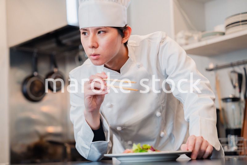 料理の盛り付けをする男性シェフ