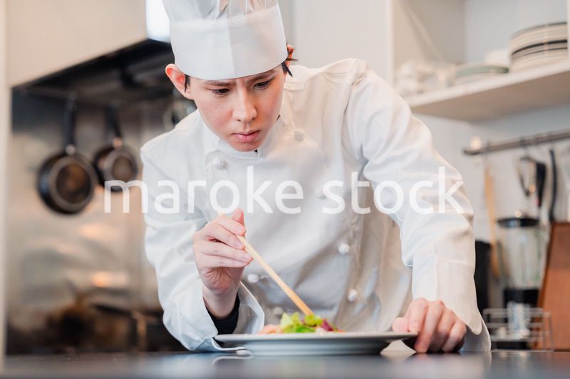 料理の盛り付けをする男性シェフ