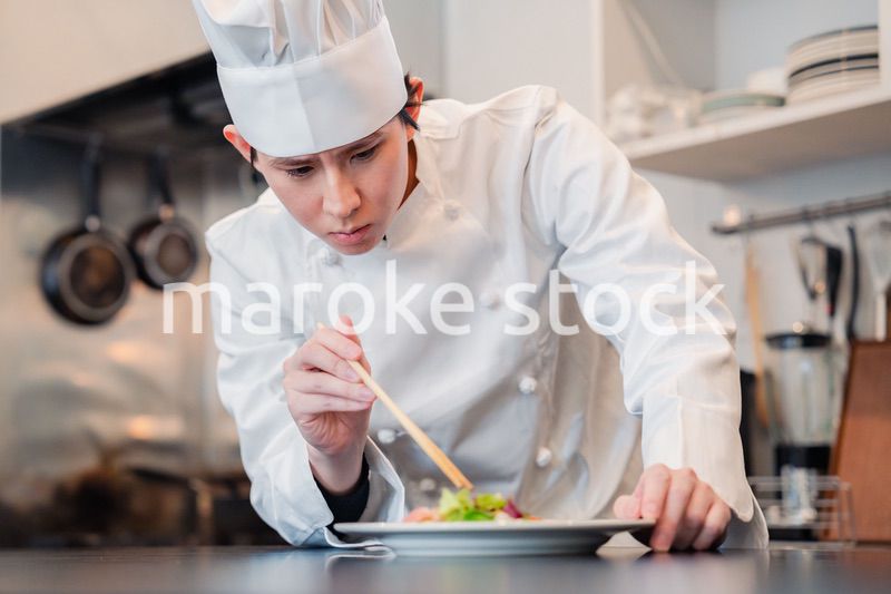 料理の盛り付けをする男性シェフ