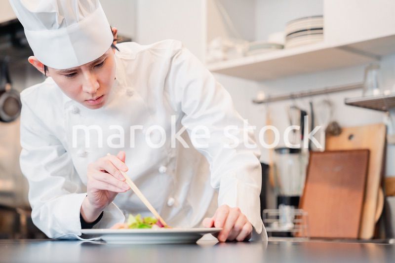 料理の盛り付けをする男性シェフ