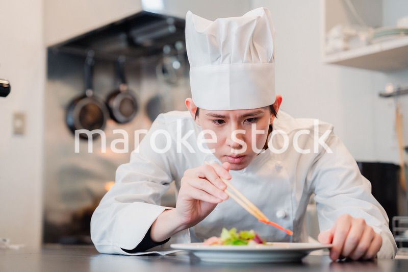料理の盛り付けをする男性シェフ