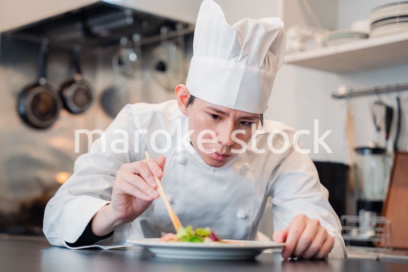 料理の盛り付けをする男性シェフ