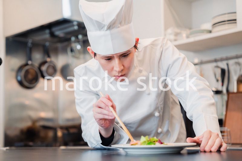 料理の盛り付けをする男性シェフ